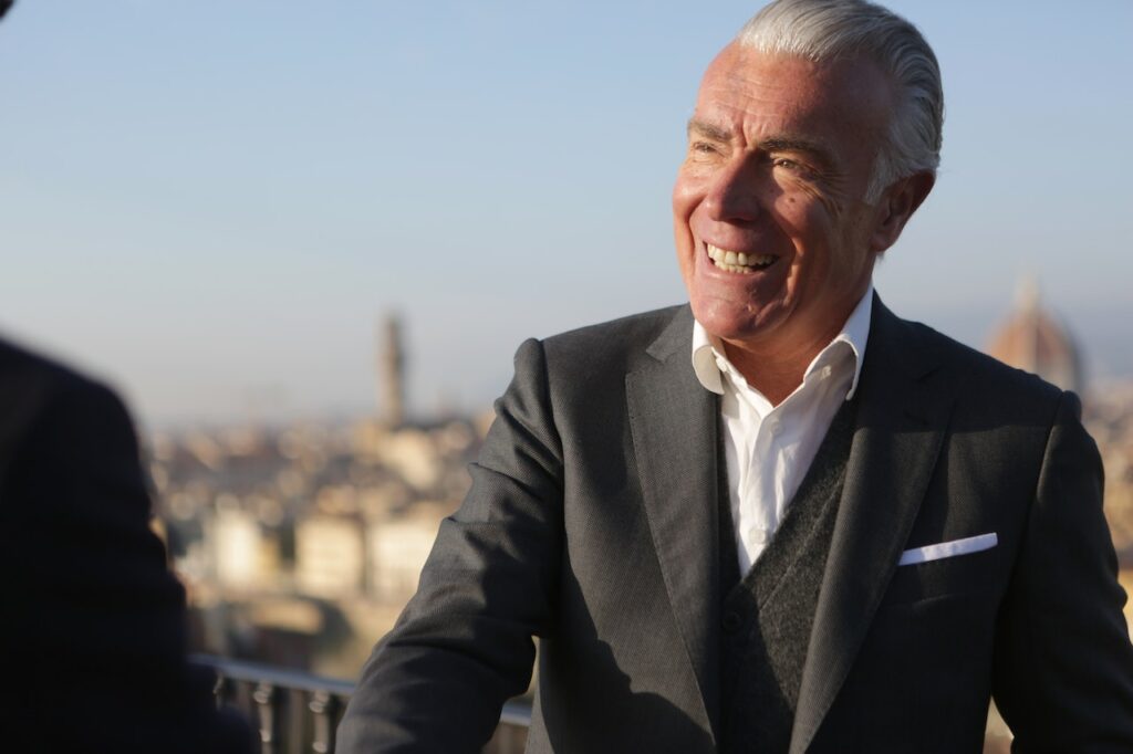 Smiling man in suit with cityscape background.